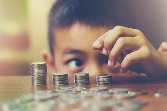 Kid counting coins and putting them in a stack.