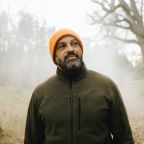 man looking up in foggy woods