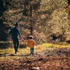 father and child walking down path