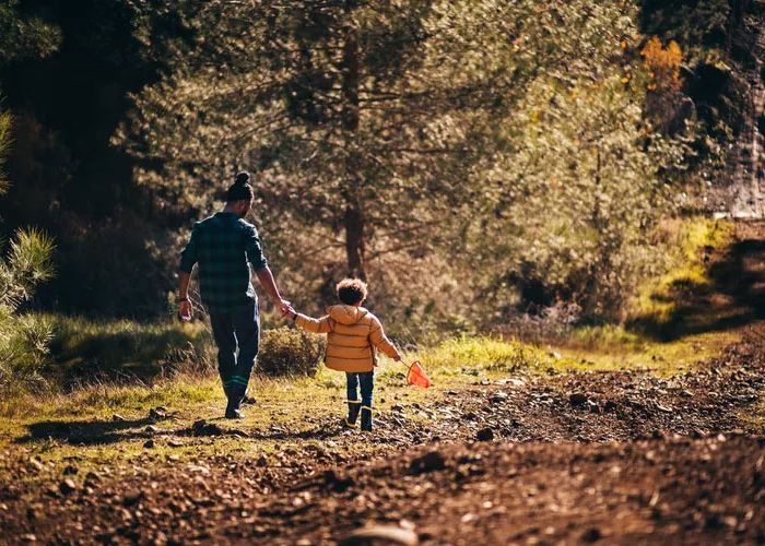 father and child walking down path
