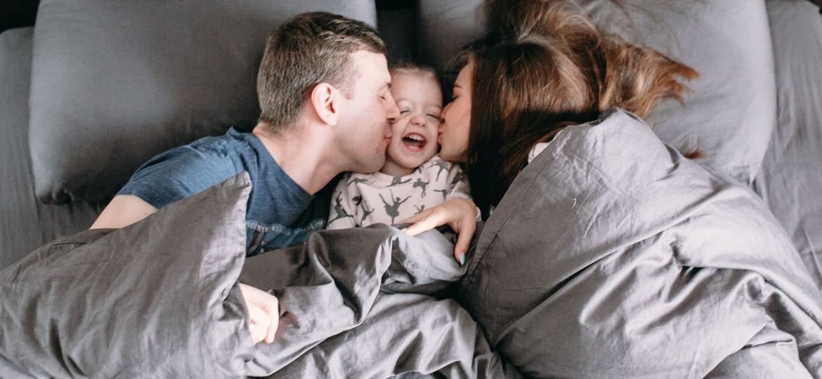 family in bed with their child