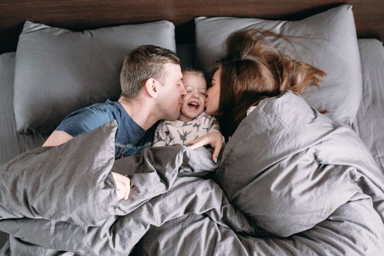 family in bed with their child